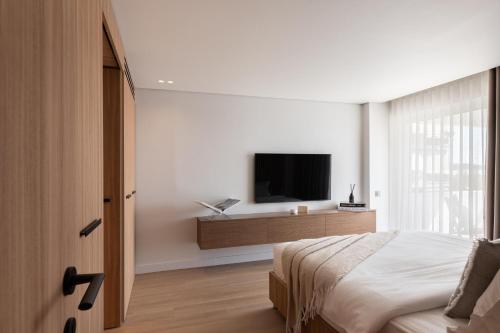 a bedroom with a bed and a tv on a wall at 1bd Sv Beach Condo With Pool in Athens