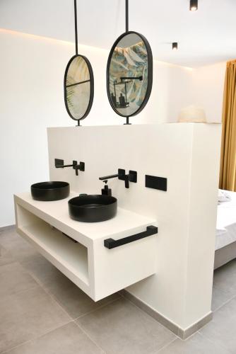 a bathroom with two sinks and two mirrors at Moddissi Charme in Trappola