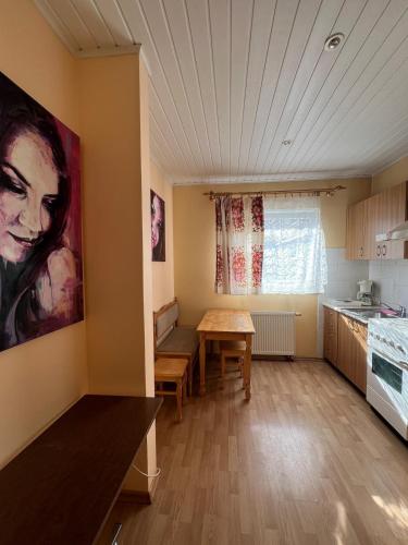 a living room with a table and a kitchen at Cozy apartment near Santariskes in Vilnius