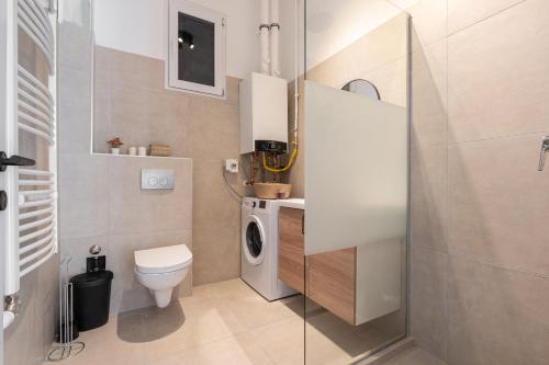 a bathroom with a toilet and a washing machine at Harmony House Apartment in Budapest