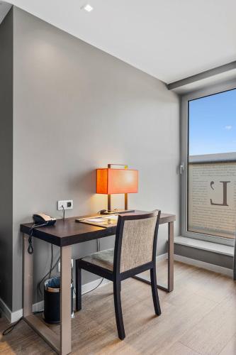 a desk with a lamp and a chair in a room at Relais de L'Empereur in Genappe