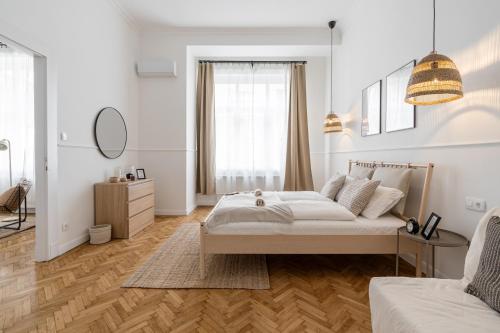 a white bedroom with a bed and a mirror at Harmony House Apartment in Budapest