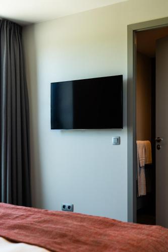 a bedroom with a flat screen tv on a wall at Relais de L'Empereur in Genappe