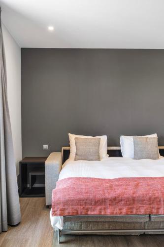 a bedroom with a large bed with white sheets and pillows at Relais de L'Empereur in Genappe