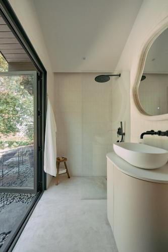 a bathroom with a white tub and a sink at Quinta do Desenho - Douro Valley - Private Pool & Sauna in Paços de Gaiolo
