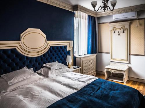 a bedroom with a large bed with a blue wall at Sky Park Home in Iaşi