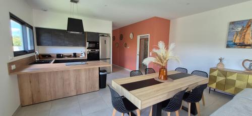 une cuisine et une salle à manger avec une table et des chaises dans l'établissement Villa REVA ,8 couchages, piscine entre terre et mer, à Nézignan-lʼÉvêque