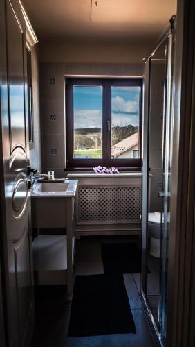 a bathroom with a large window and a sink at Sky Park Home in Iaşi