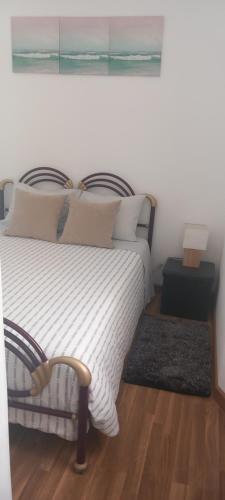 ein Schlafzimmer mit einem Bett und einem Gemälde an der Wand in der Unterkunft A casinha in Nazaré