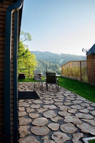 two chairs and a table on a stone patio at Termalna Osada in Brenna