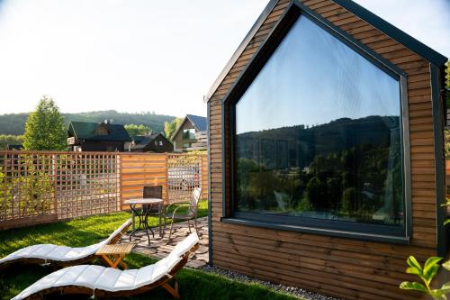 a house with a large window with a table and chairs at Termalna Osada in Brenna
