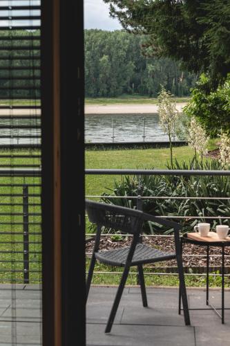 a bench sitting on a porch with a view of a lake at NOOQA - Villa RHEINLOFTS in Cologne