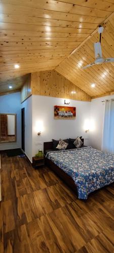 a bedroom with a bed and a wooden ceiling at Sunshine Cottages in Bīr