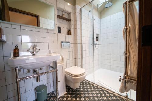 a bathroom with a sink and a toilet and a shower at The Bell in Ticehurst in Ticehurst