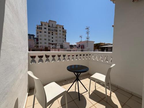 a balcony with a table and chairs on a roof at VMC Rooms in Tavernes de Valldigna