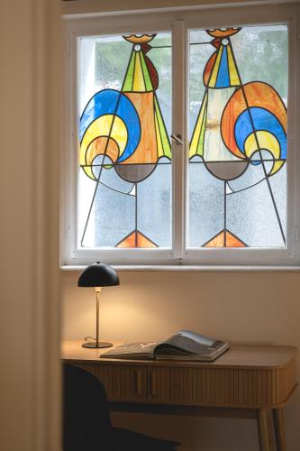 a window with a desk with a lamp in front of it at NOOQA - Villa RHEINLOFTS in Cologne