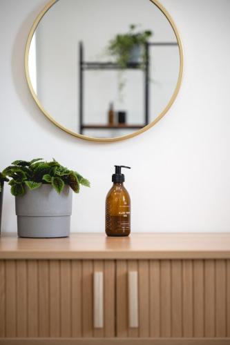 a bottle of soap on a counter with a mirror at NOOQA - Villa RHEINLOFTS in Cologne