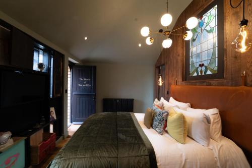 a bedroom with a large bed and a tv at The Bell in Ticehurst in Ticehurst