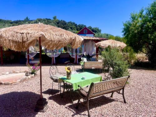 a patio with a table and a straw umbrella at Apartamentos la Jayma del Arte in Asque