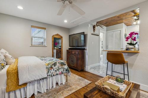 a bedroom with a bed and a television and a chair at The Cultural District Cottage in Fort Worth