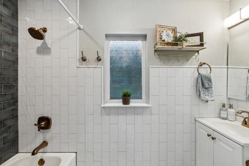 a white bathroom with a sink and a window at The Cultural District Cottage in Fort Worth