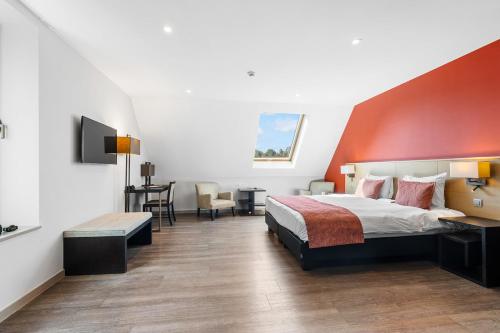 a bedroom with a large bed and a red wall at Relais de L'Empereur in Genappe