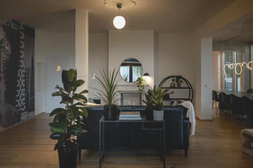 a living room with a couch and a table with plants at NOOQA - Villa RHEINLOFTS in Cologne