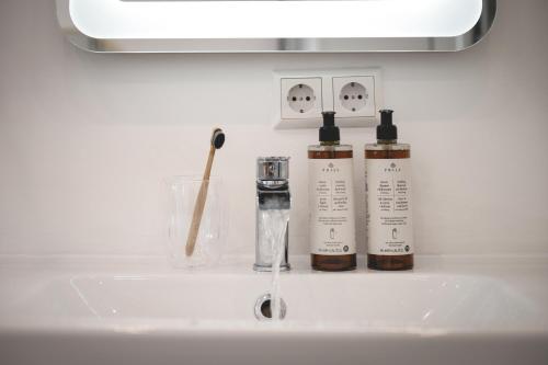 two bottles ofodorizers sitting on a bathroom sink at NOOQA - Villa RHEINLOFTS in Cologne