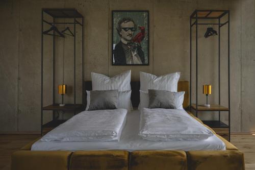 a bedroom with two beds and a portrait of a man at NOOQA - Villa RHEINLOFTS in Cologne