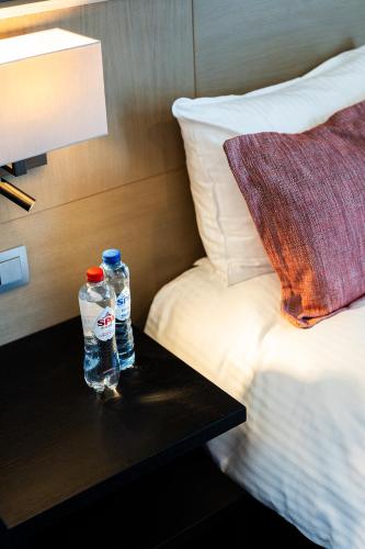 two bottles of water on a table next to a bed at Relais de L'Empereur in Genappe