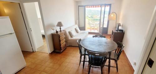 un salon avec une table, des chaises et un canapé dans l'établissement Comfortable 40 m apartment with sea view, à Sainte-Maxime