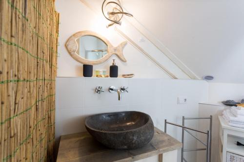 a bathroom with a vessel sink and a mirror at Silver Moon Bed & Breakfast in Voorschoten