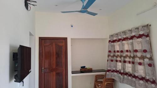 a room with a ceiling fan and a door at Roshni Apartment - 2A in Vishāram