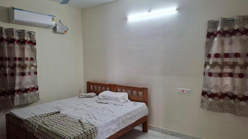 a small bedroom with a bed and curtains at Roshni Apartment - 2A in Vishāram