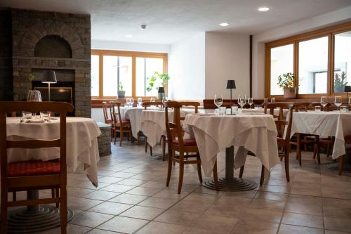 a dining room with tables and chairs and a fireplace at Residenza Del Sole in Gressoney-Saint-Jean