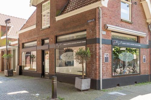 a store front of a brick building with a clock in the window at Silver Moon Bed & Breakfast in Voorschoten