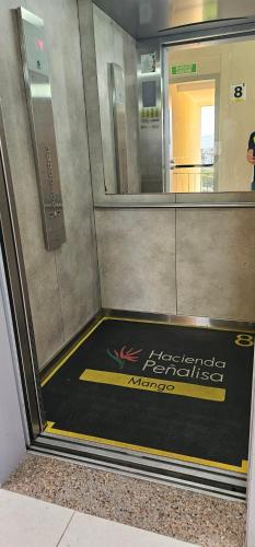 an entrance to an elevator with a sign on the floor at Hacienda Peñalisa Mango in Ricaurte