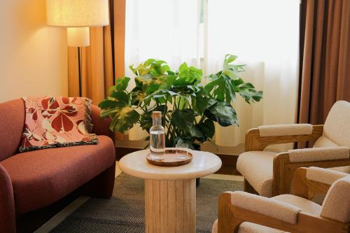 a living room with chairs and a table and a plant at Municipal Grand in Savannah