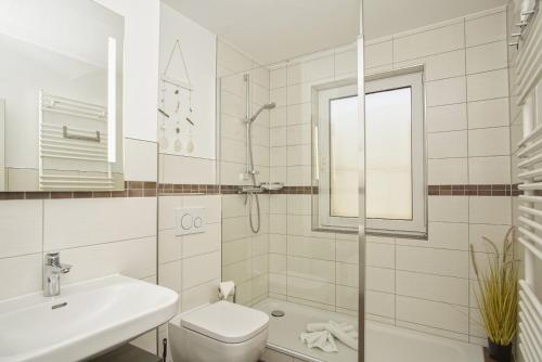 ein weißes Badezimmer mit Toilette und Waschbecken in der Unterkunft strandnahe Ferienwohnung mit eigener Terrasse - Strandhaus Mönchgut FeWo 02 in Lobbe