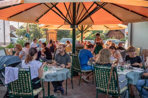 um grupo de pessoas sentadas às mesas de um restaurante em Pension Oberjörg em Rattendorf