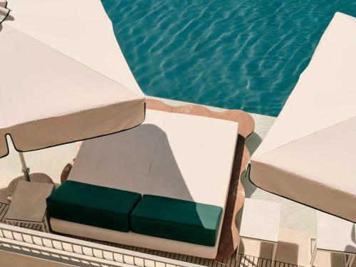 a table and chairs next to a swimming pool at Mangia's Torre Del Barone Resort & SPA in Sciacca
