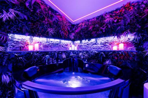 a bathroom with a tub with purple lights and plants at Villa Libertà in Palermo