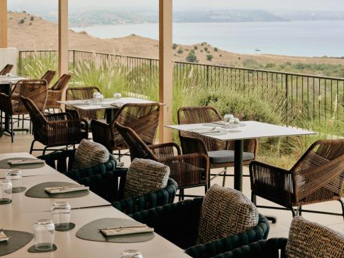 a restaurant with tables and chairs and a view of the ocean at Mangia's Torre Del Barone Resort & SPA in Sciacca