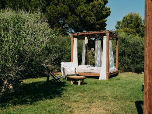 a bed in a garden with a canopy at Mangia's Torre Del Barone Resort & SPA in Sciacca