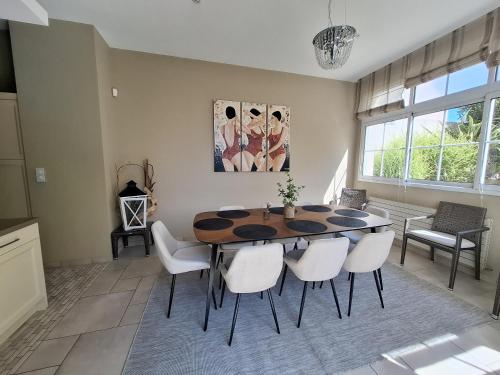une salle à manger avec une table et des chaises blanches dans l'établissement Villa Dilecta - Superbe vue mer - garage, à La Rudelière