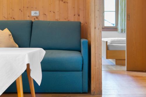 a blue couch in a room with a table at Unterdornerhof Algund in Lagundo