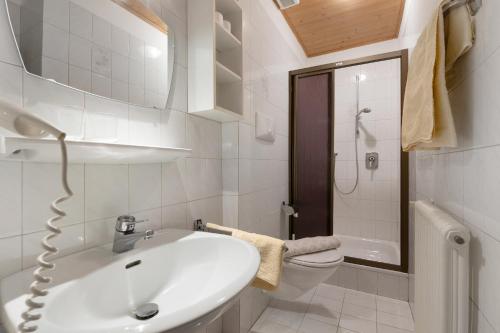 a white bathroom with a sink and a toilet at Unterdornerhof Algund in Lagundo