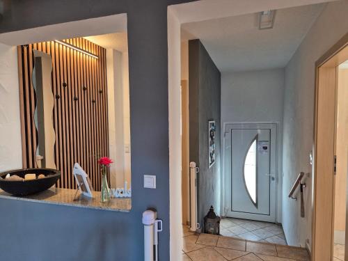 einen Flur mit blauen Wänden und eine Tür mit einem Spiegel in der Unterkunft Ferienhaus Seefried in Baiersbronn