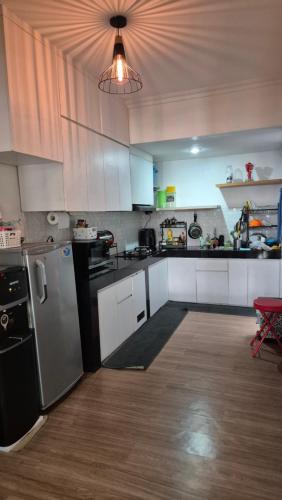 a kitchen with white cabinets and a stainless steel refrigerator at Dago Family Stay in Bandung