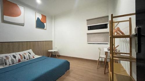a bedroom with a blue bed and a desk at Dago Family Stay in Bandung